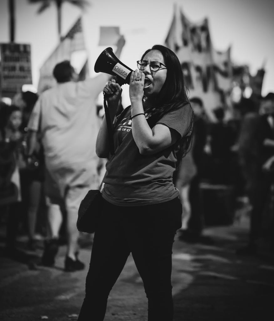 Black and white African American woman in glasses screaming with speaker while visiting political meeting